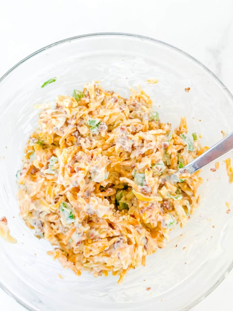 Overhead photo of Nieman Marcus Dip ingredients combined in a clear glass mixing bowl