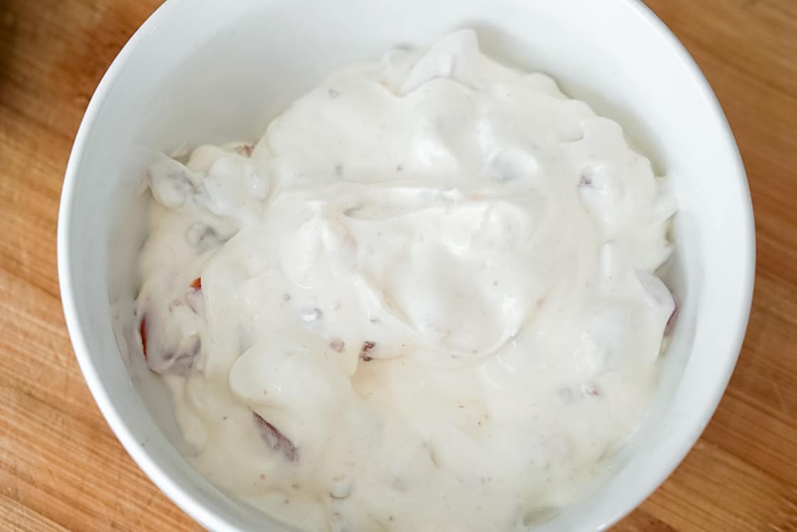 blt dip in a white bowl after being mixed