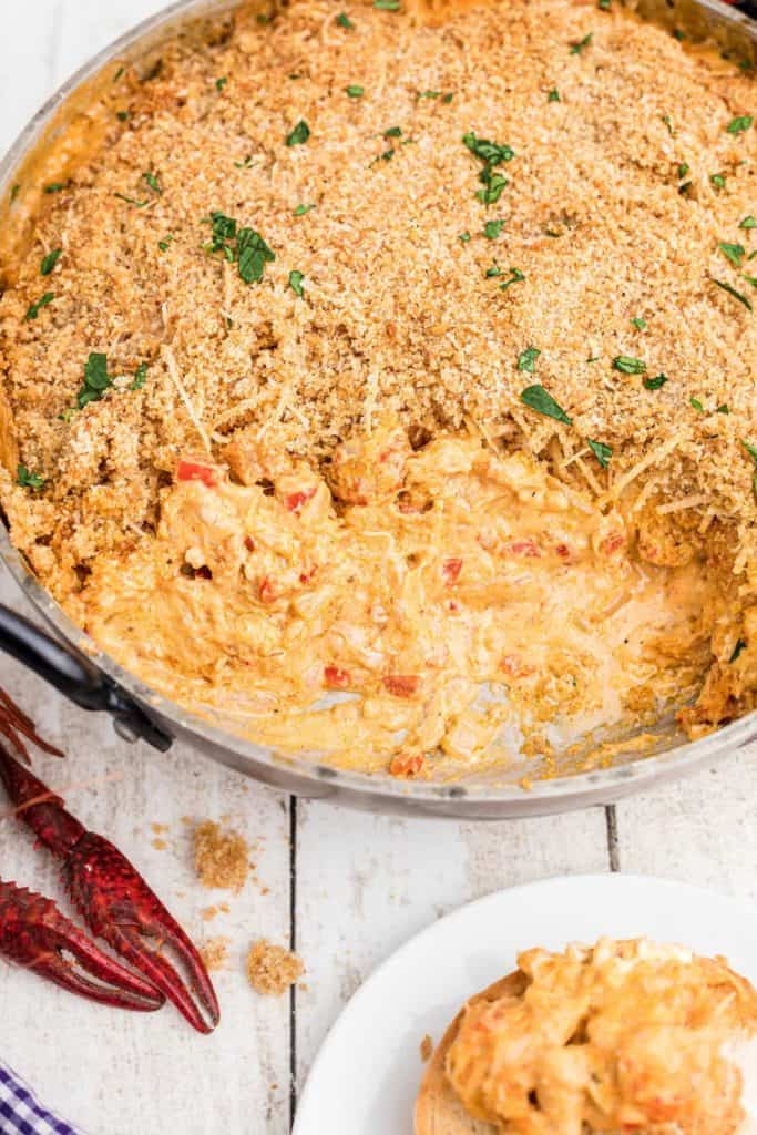 large skillet full of crawfish dip, topped with breadcrumbs