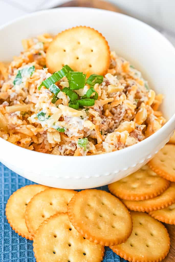 Closeup photo of Neiman Marcus dip in a white bowl with buttery round crackers on the side