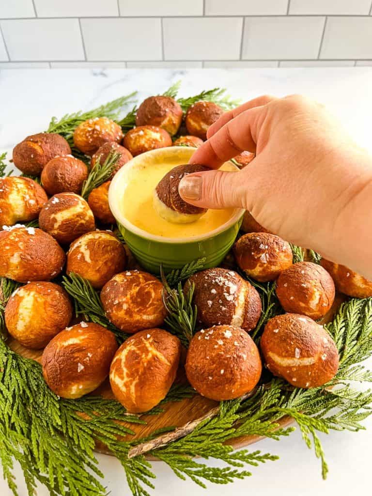 pretzel bite being dipped in beer cheese dip