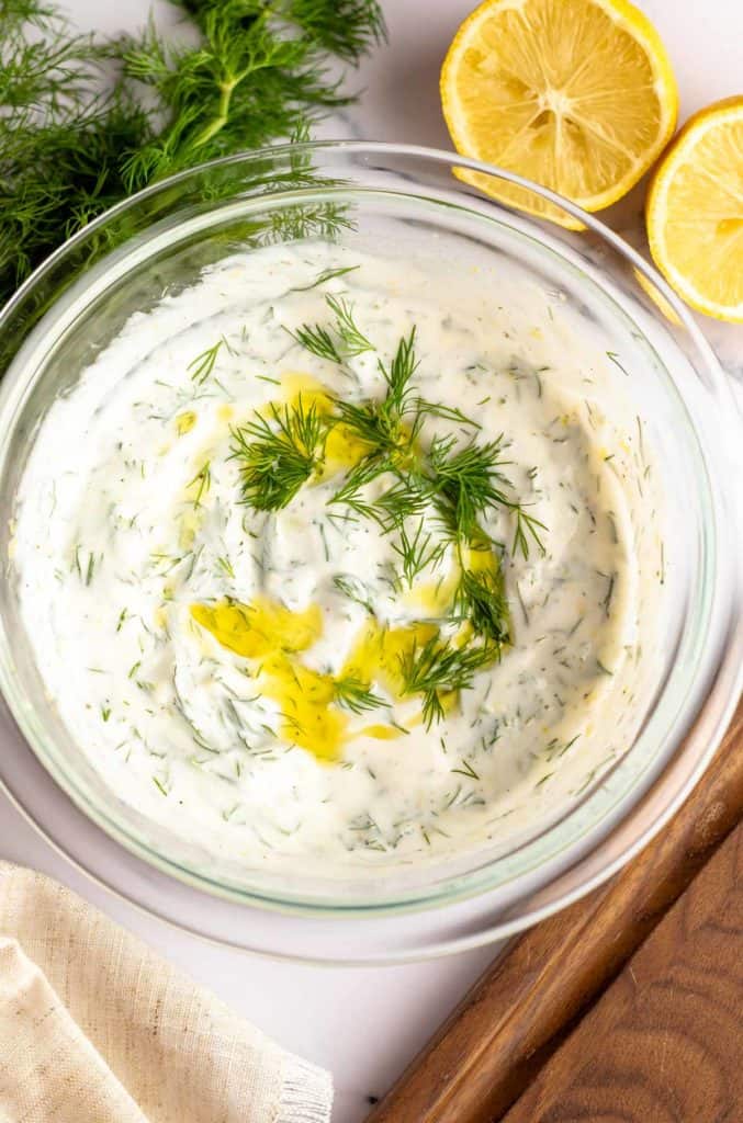 homemade yogurt dill dip in a bowl with fresh dill garnish