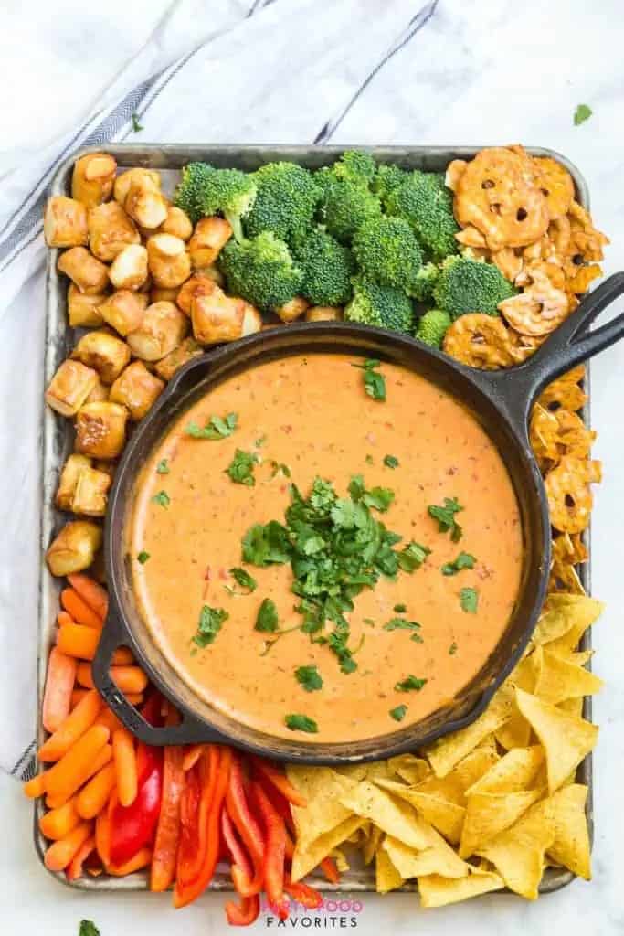 overhead photo of Velveeta beer cheese dip in a cast iron skillet with dippers on the side