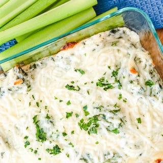 hot spinach dip from the oven with celery stick on the side