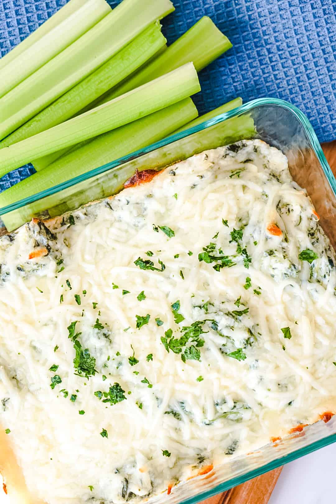 hot spinach dip from the oven with celery stick on the side