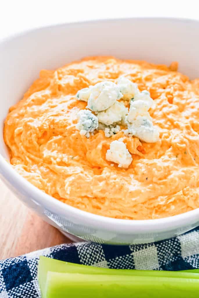 Franks Red Hot Buffalo Chicken Dip in a white bowl with blue cheese crumbles as a garnish