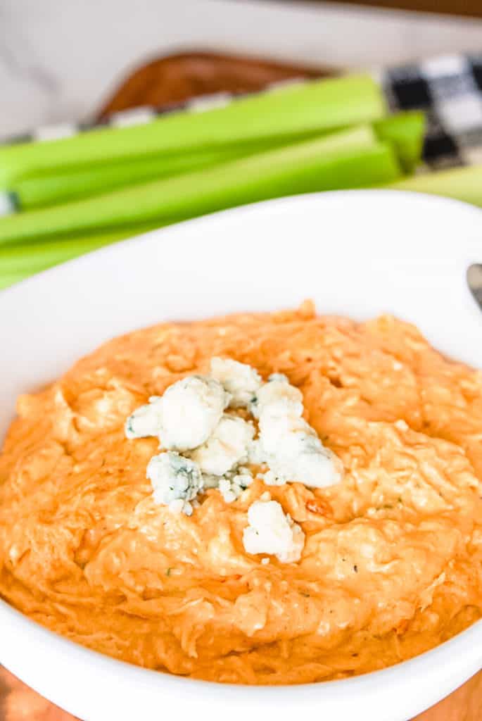 prepared franks red hot buffalo chicken dip in a white bowl with blue cheese crumbles on top
