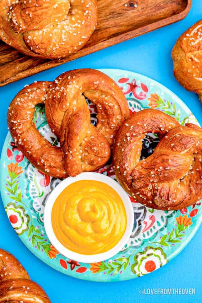 homemade soft pretzels on a colorful plate with mustard dip