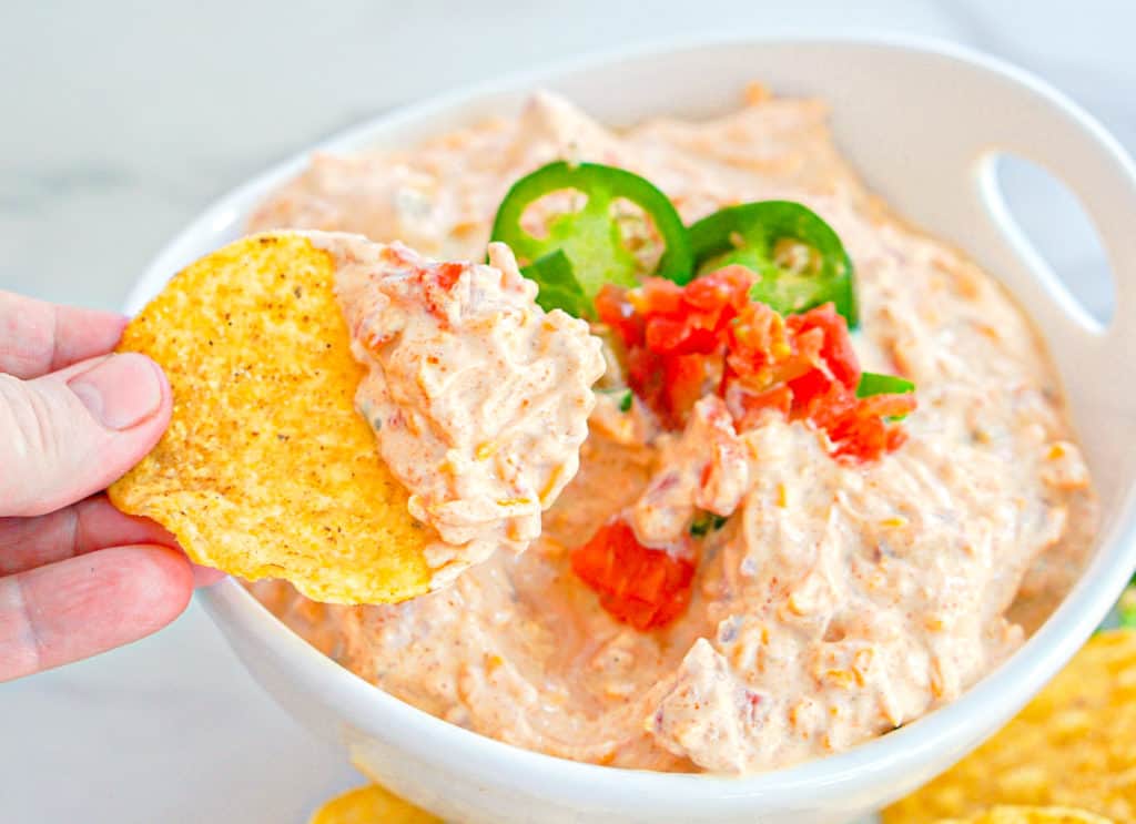 tortilla chip being dipped in taco dip