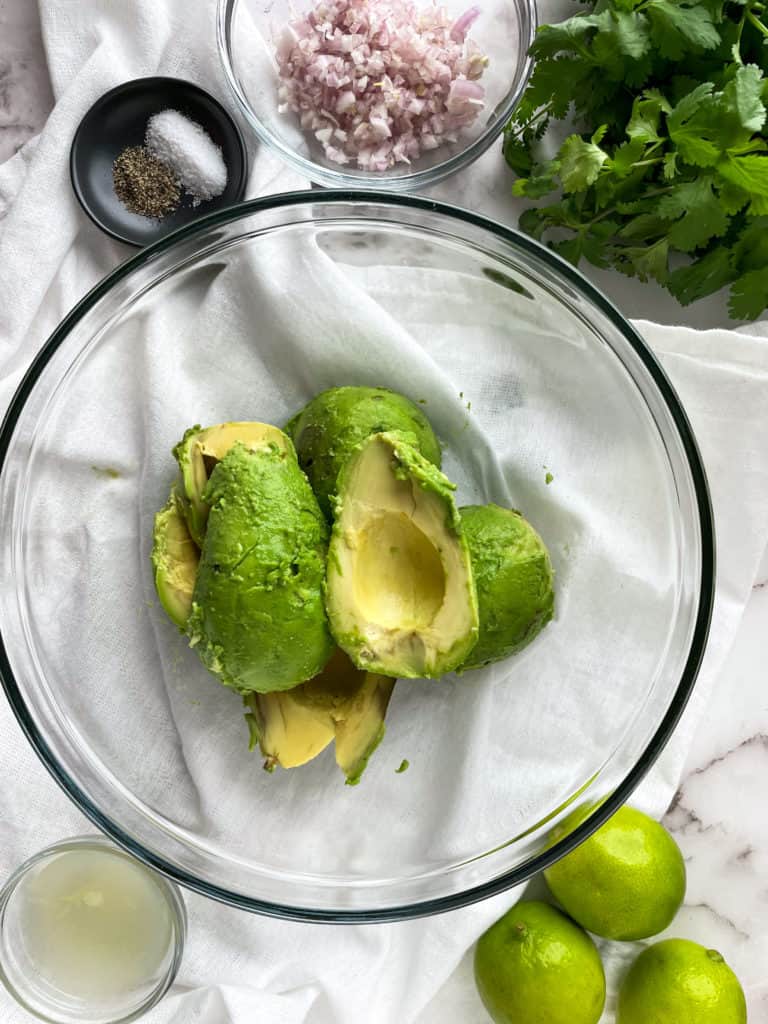 avocado scooped out from the skin in a clear bowl