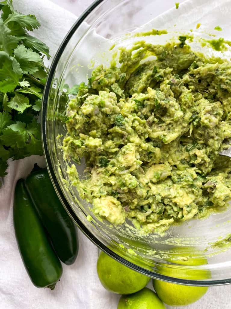 up close shot of mashed avocado in a clear bowl
