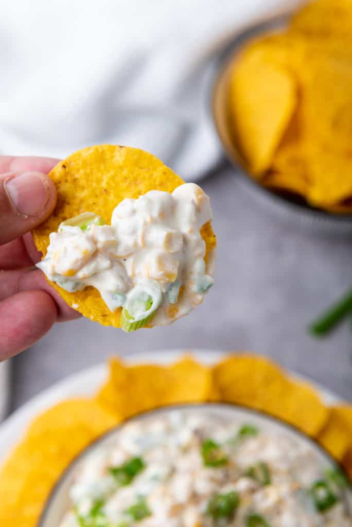 corn dip being scooped on a round tortilla chip
