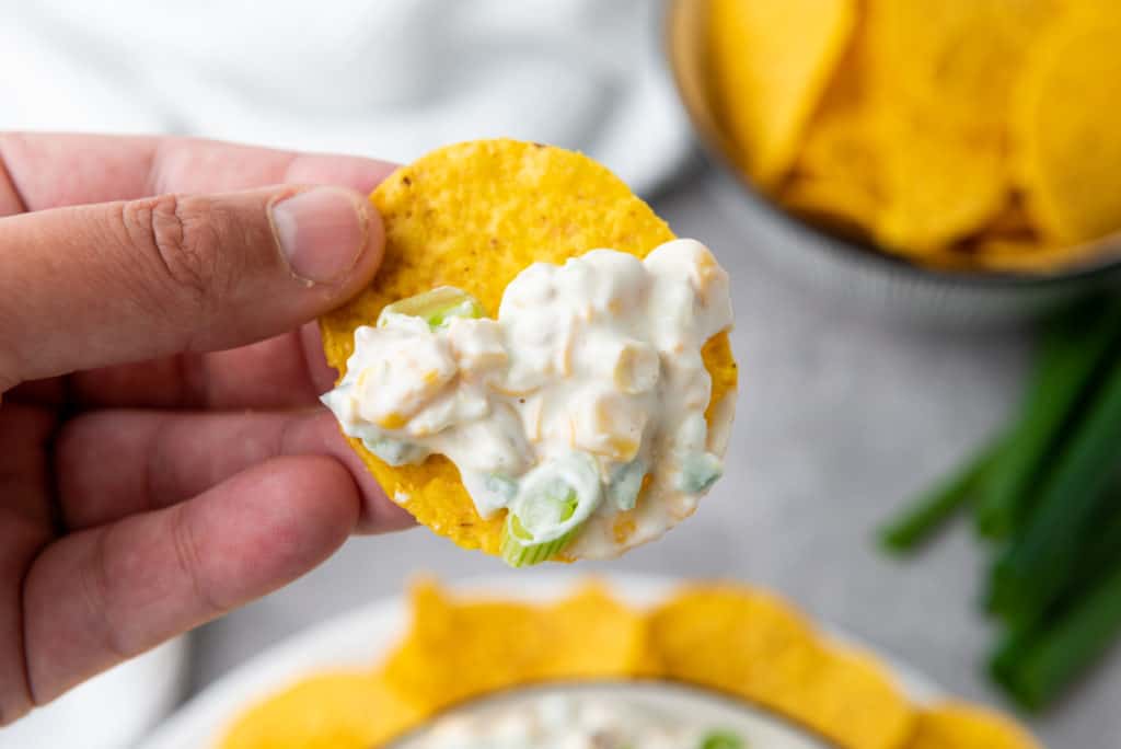 creamy corn dip on a yellow corn tortilla chip