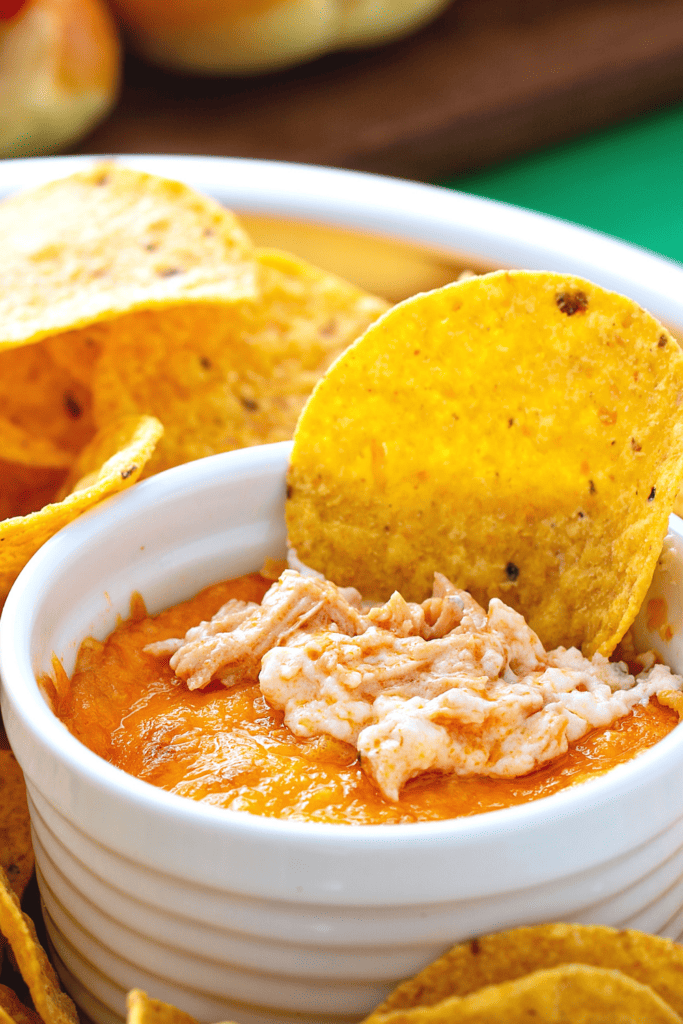 buffalo chicken dip in a white ramekin with a round tortilla chip