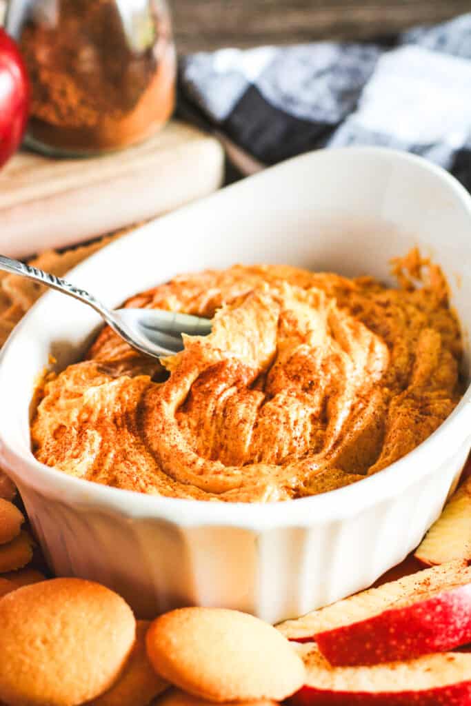 spiced pumpkin dip in a white bowl with a spoon
