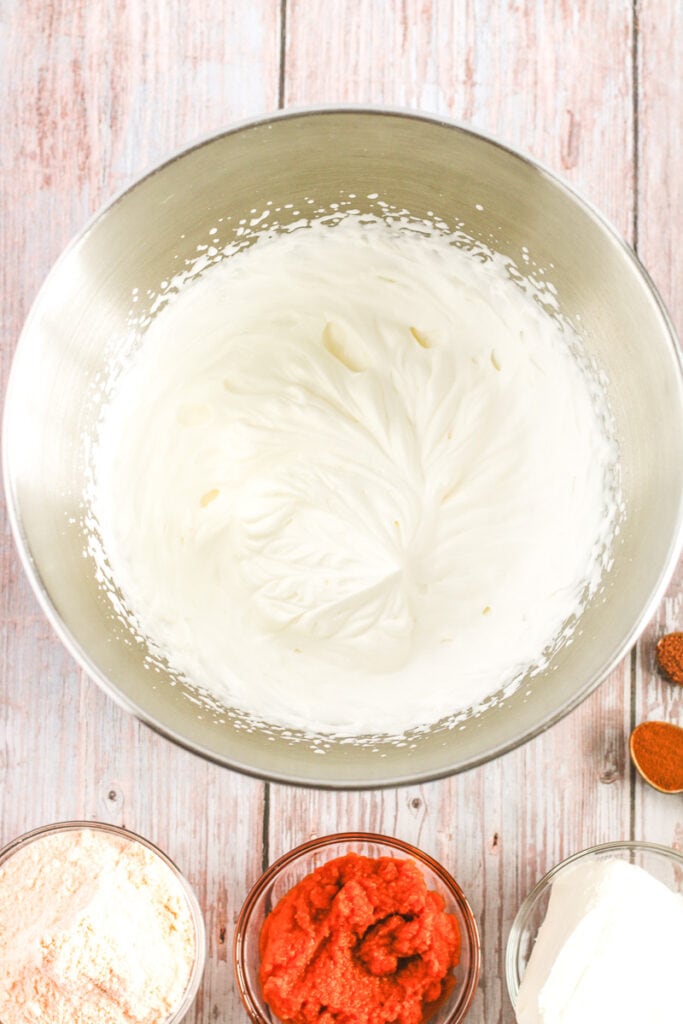 heavy cream in a mixing bowl with stiff peaks