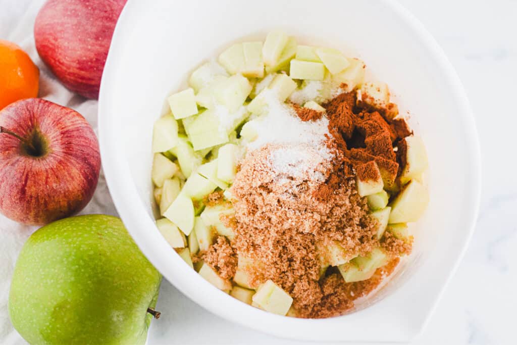 dry ingredients for apple pie dip on a white mixing bowl