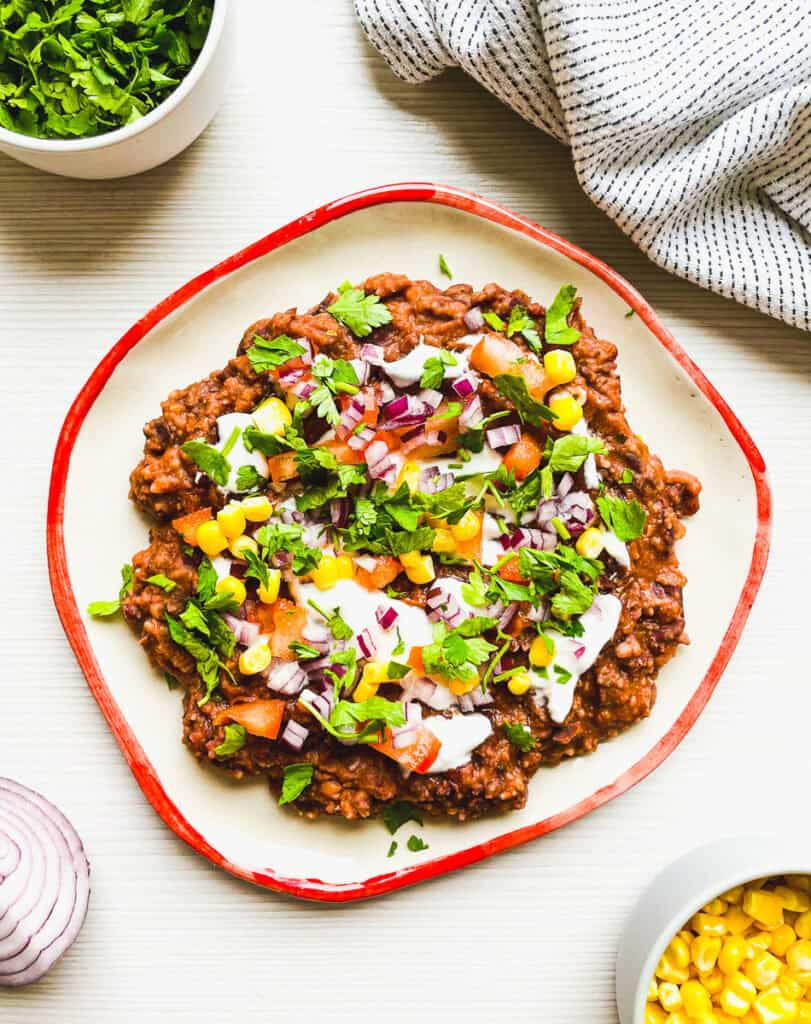 loaded black bean dip in a bowl with all the fixings perfect for game day or taco night