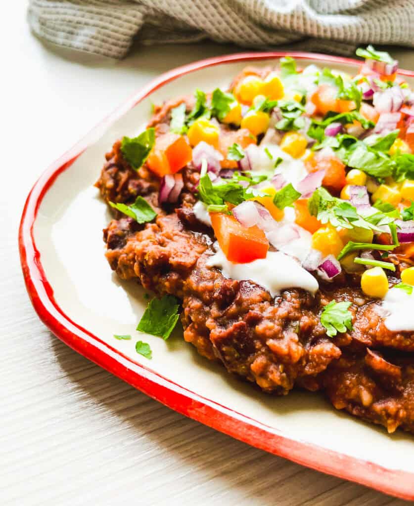 closeup of black bean dip with chunky beans and toppings