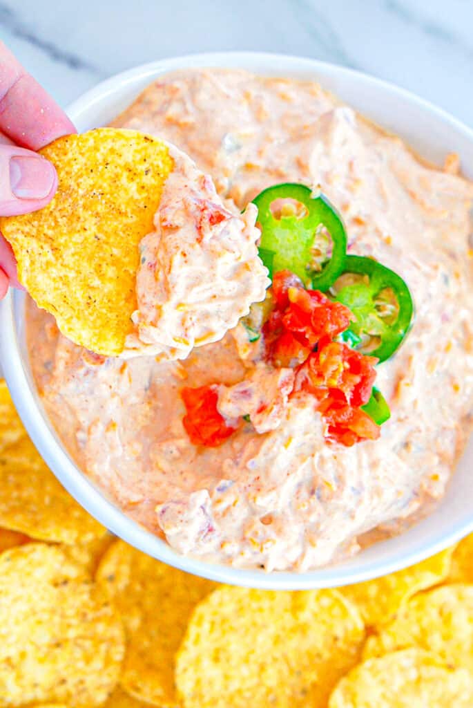 Overhead shot of chip with boat dip over a bowlful of more boat dip