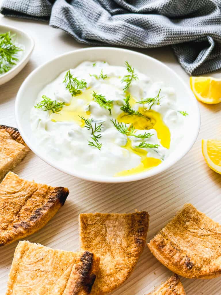 tzatziki in bowl with pita bread on the side