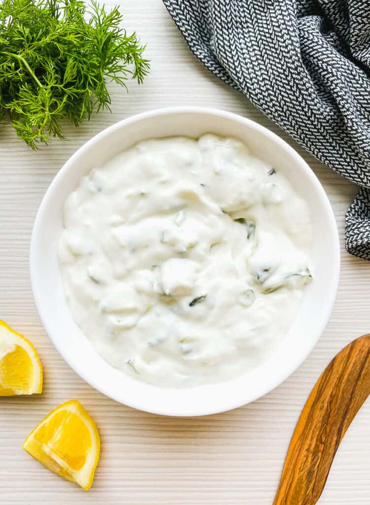 homemade tzatziki with sour cream with fresh dill and lemon on the side