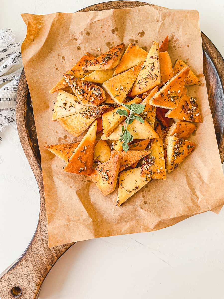 baked Zaatar Pita Chips on a round cutting board