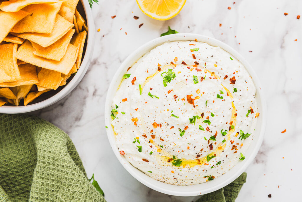 prepared whipped feta in a bowl with a side of pita chips