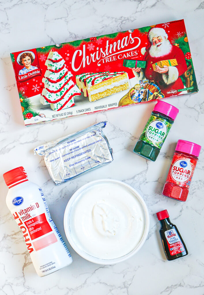 ingredients for christmas tree cake dip made with little debbie snack cakes, cream cheese, whipped topping, milk, vanilla and holiday sprinkles