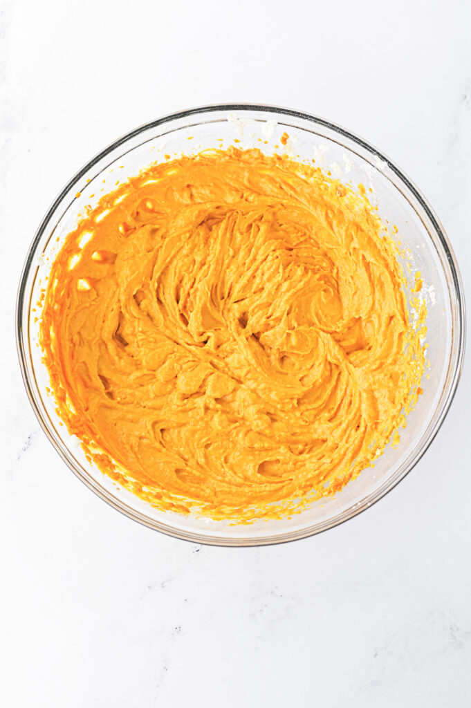 pumpkin pie dip ingredients mixed with a handheld mixer
