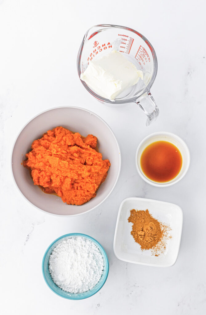 ingredients for pumpkin pie dip including pumpkin puree, pumpkin pie spice, vanilla, cream cheese and powered sugar