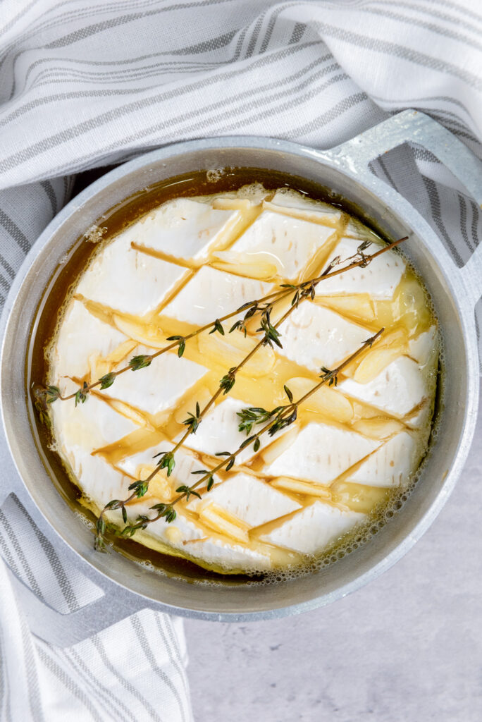 baked brie with honey and garlic with rosemary sprigs right out of the oven