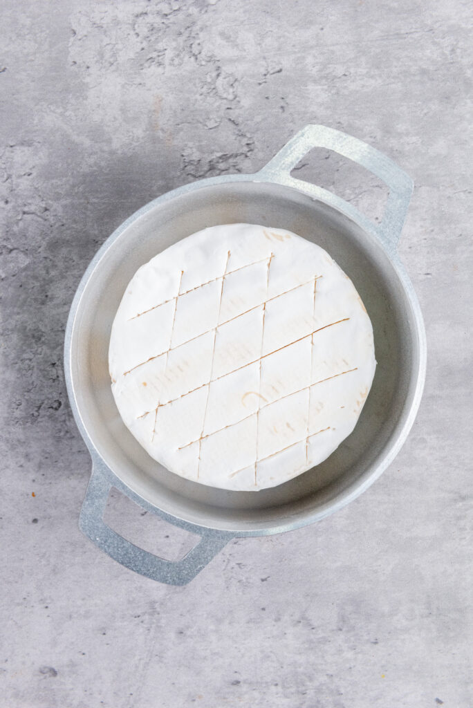 brie wheel in a brie baker with slits