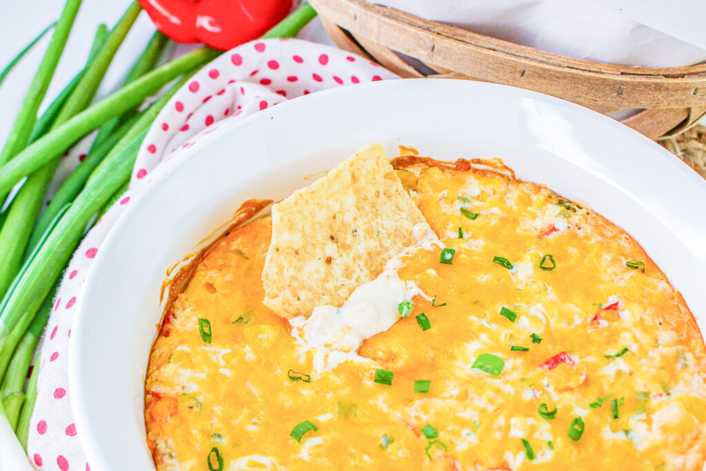 tortilla chip dipped in hot corn dip 