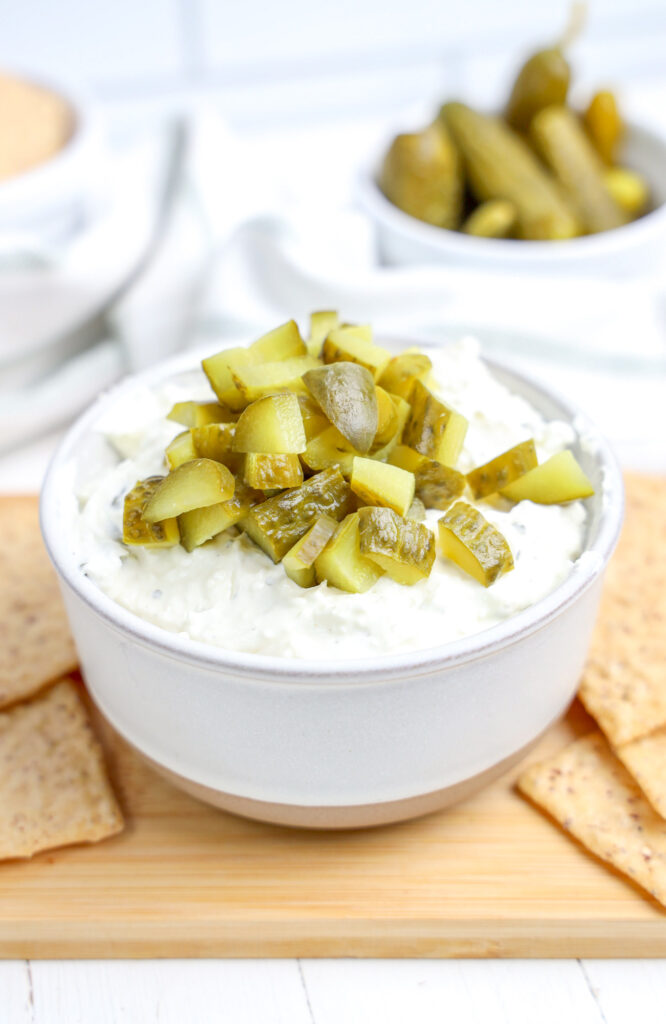 prepared dill pickle dip with chopped pickles on top of a creamy dip.