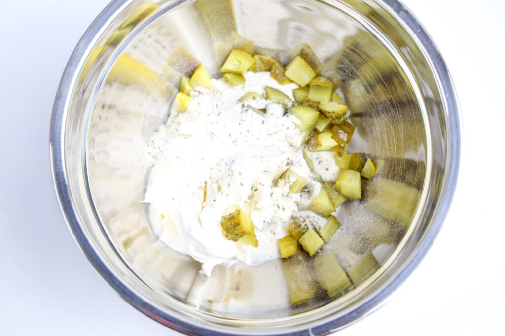 dill pickle dip ingredients in a silver mixing bowl