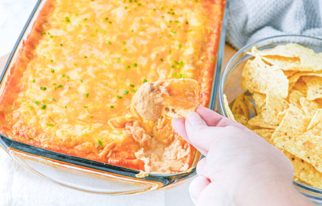 corn tortilla chip being dipped in texas trash bean dip