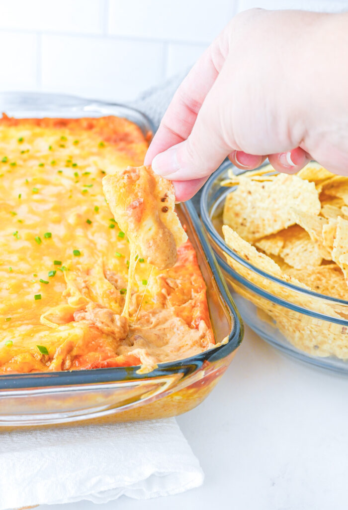 tortilla chip with hot bean dip and melty cheese