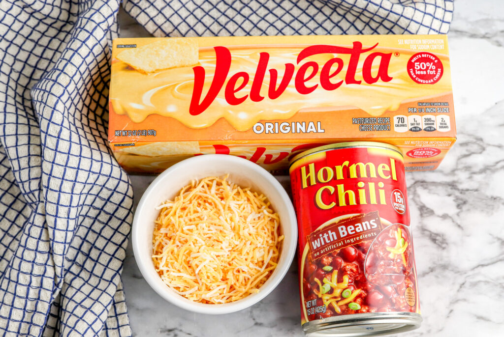 a box of Velveeta cheese, Hormel chili with beans and Fiesta cheese on a counter