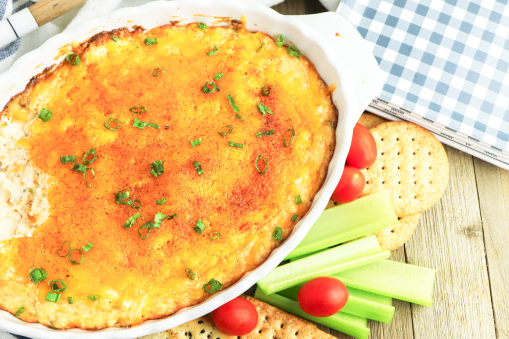 warm cajun crab dip out of the oven with garnish and dippers on the side