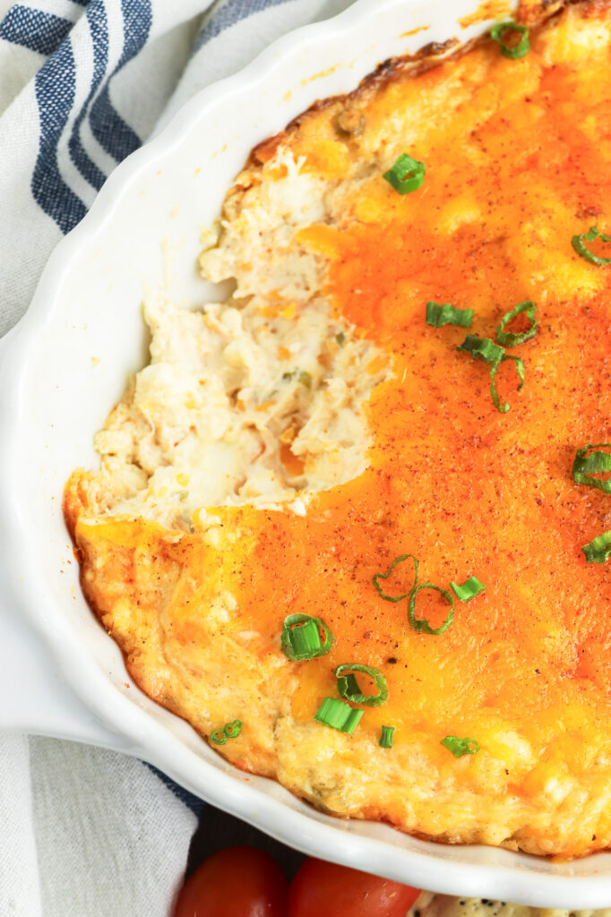 prepared hot cajun crab dip with a scoop taken out of it 