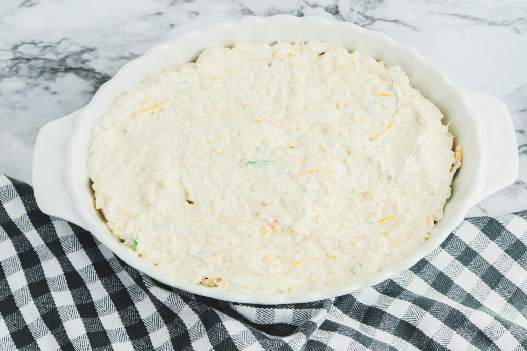 crab dip spread into a baking dish before cooking