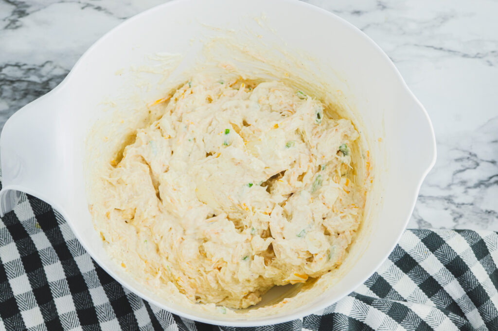 mixed ingredietns in a white bowl for crab dip before baking