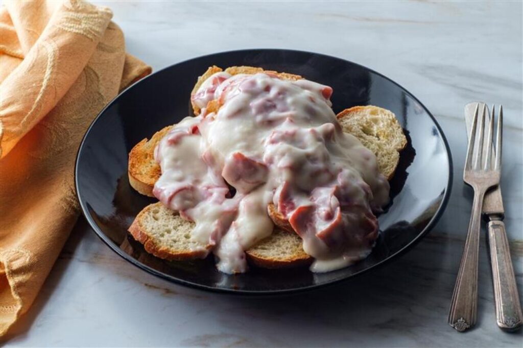 Creamed and chipped beef on sliced toast on marble kitchen table also known as S.O.S.