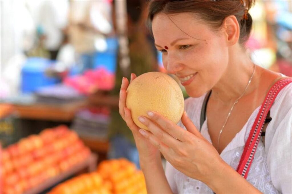 Young woman sniffing fruit