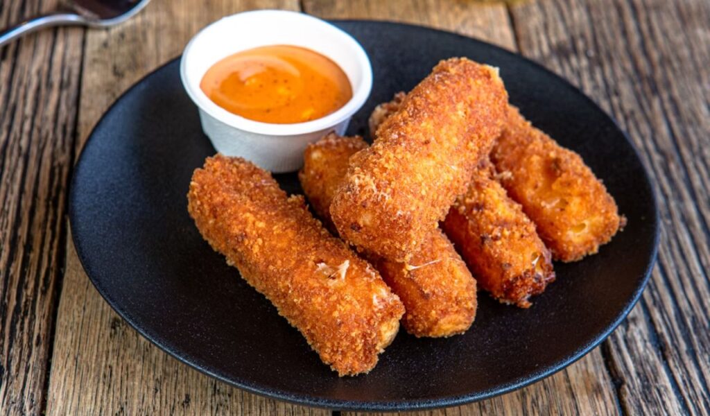 A black plate with mozzarella sticks