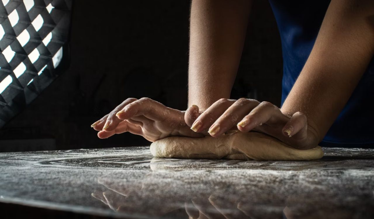 A persons hands kneading on table