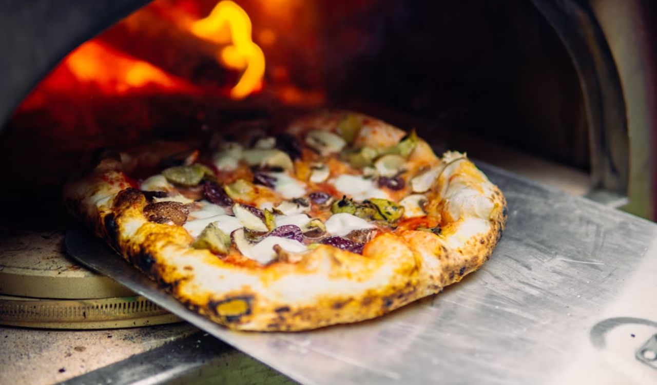 A picture of a freshly cooked pizza in the wood-fire oven.