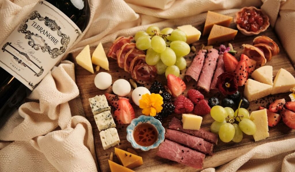 A wooden board topped with lots of different types of cheese