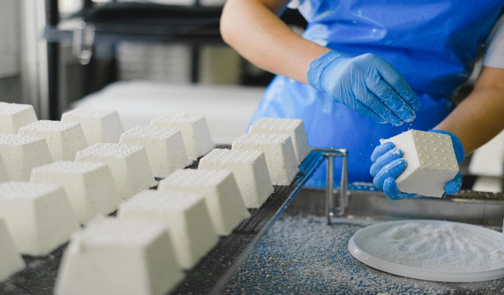 Man Making Ricotta Cheese in a Dairy Factory